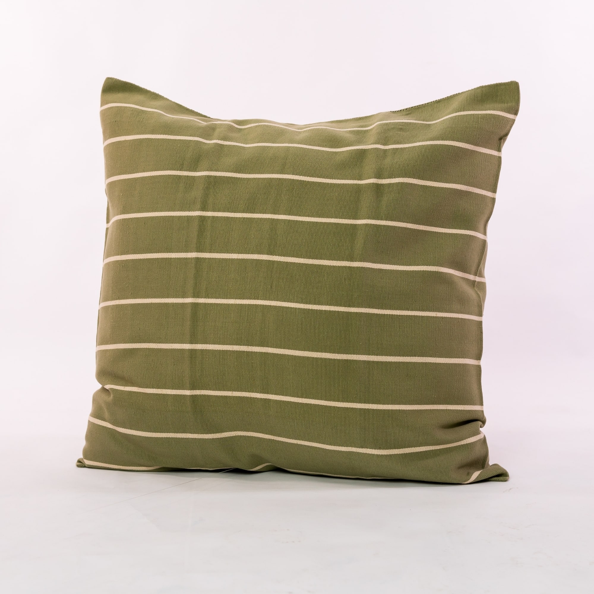 Green pillow cover crafted by the artisans of Magnolia Casual called the Rayas 2 Pillow Cover Green featuring handwoven textile, handcrafted shown against a clean backdrop featuring shades of green.