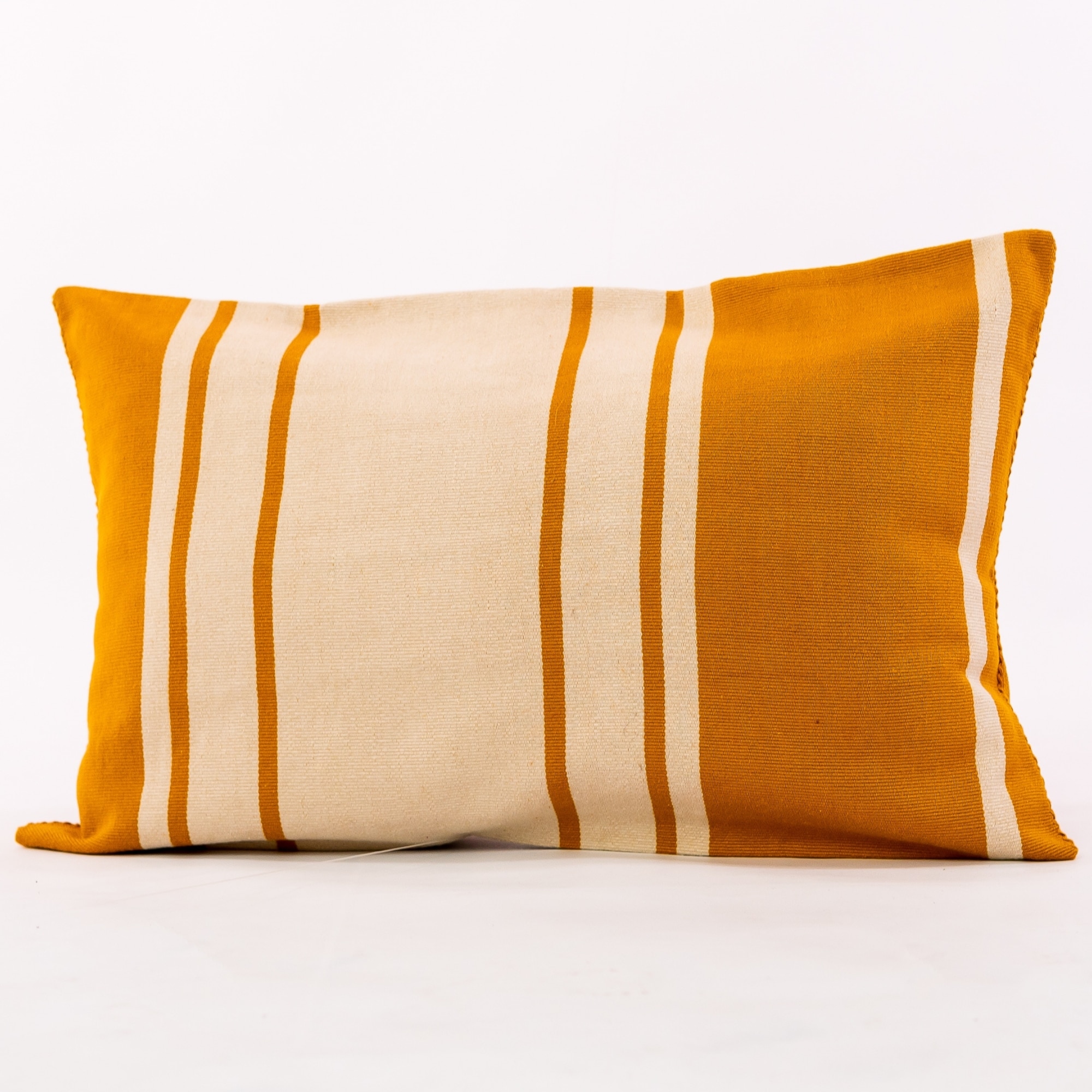 Gold outdoor pillow crafted by the artisans of Dos Tierras called the Toloyal Lumbar Pillow Gold featuring handwoven textile, handcrafted shown against a clean backdrop featuring shades of gold.