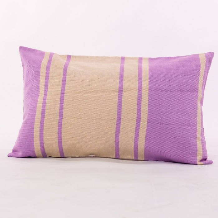 Purple outdoor pillow crafted by the artisans of Dos Tierras called the Toloyal Lumbar Pillow Purple featuring handwoven textile, handcrafted shown against a clean backdrop featuring shades of purple.