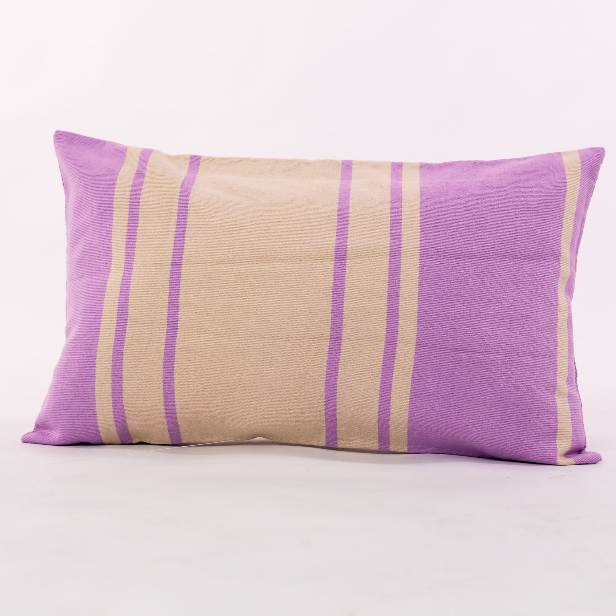 Purple outdoor pillow crafted by the artisans of Dos Tierras called the Toloyal Lumbar Pillow Purple featuring handwoven textile, handcrafted shown against a clean backdrop featuring shades of purple.