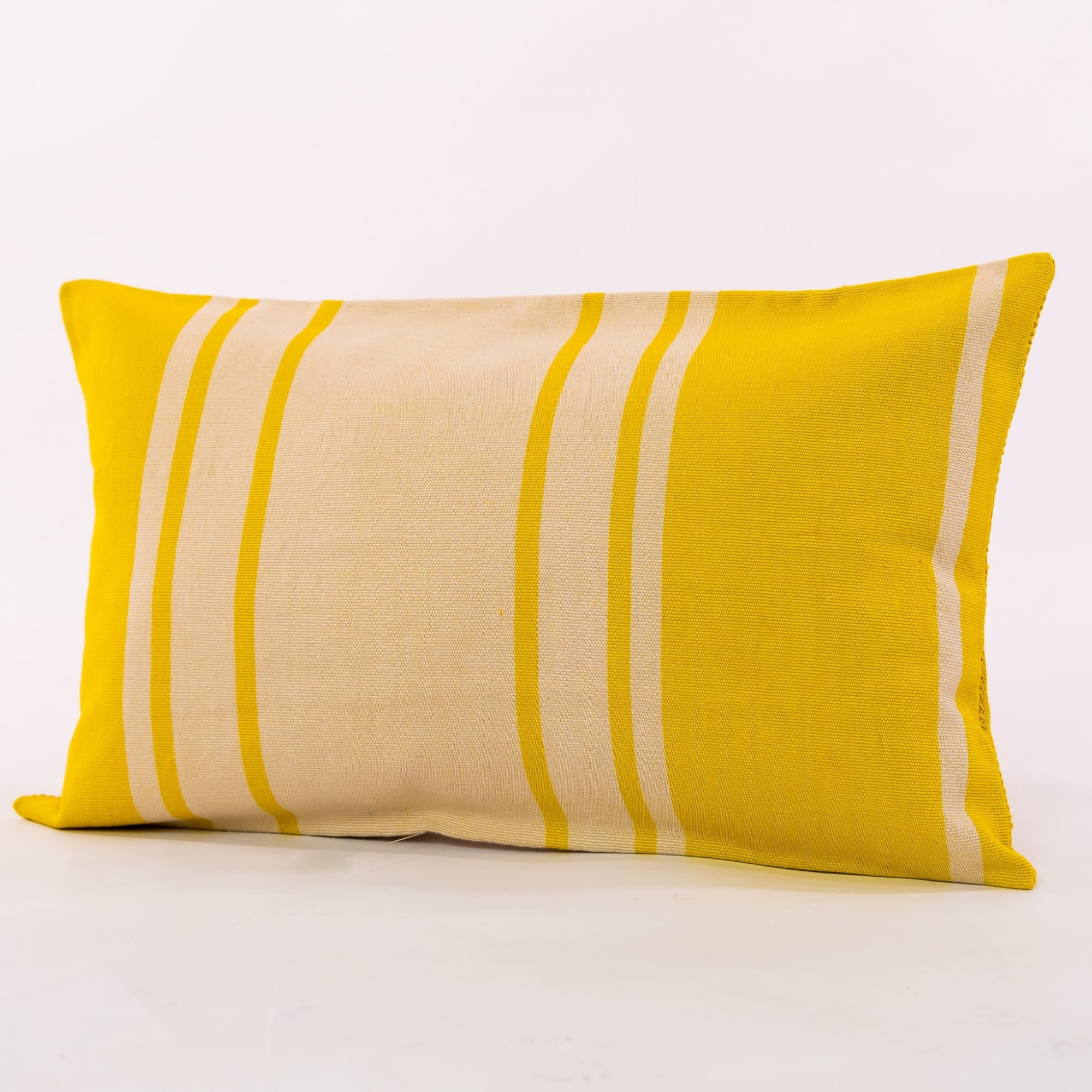 Yellow outdoor pillow crafted by the artisans of Dos Tierras called the Toloyal Lumbar Pillow Yellow featuring handwoven textile, handcrafted shown against a clean backdrop featuring shades of yellow.