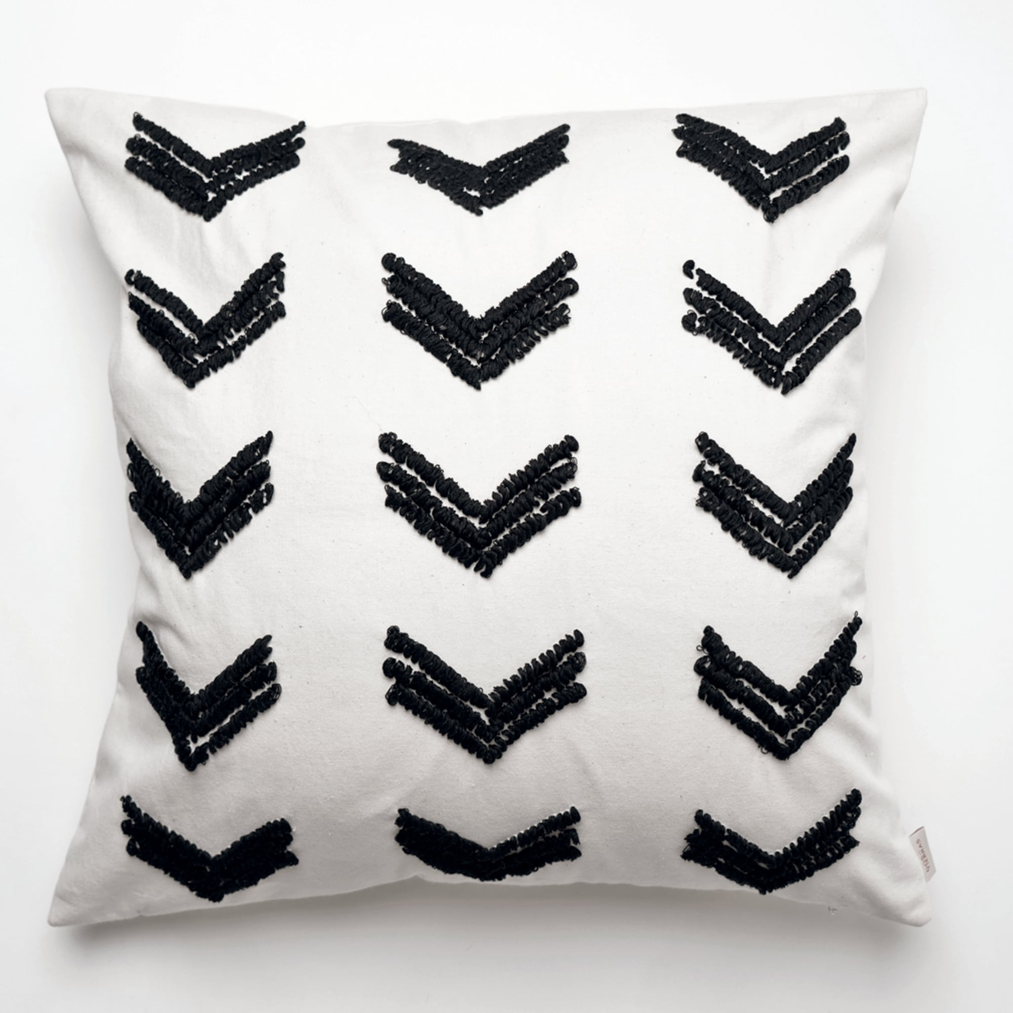 Black pillow cover crafted by the artisans of Dos Tierras called the Tuk Pillow Cover Black featuring quality outdoor fabric, handcrafted shown against a clean backdrop featuring shades of black.