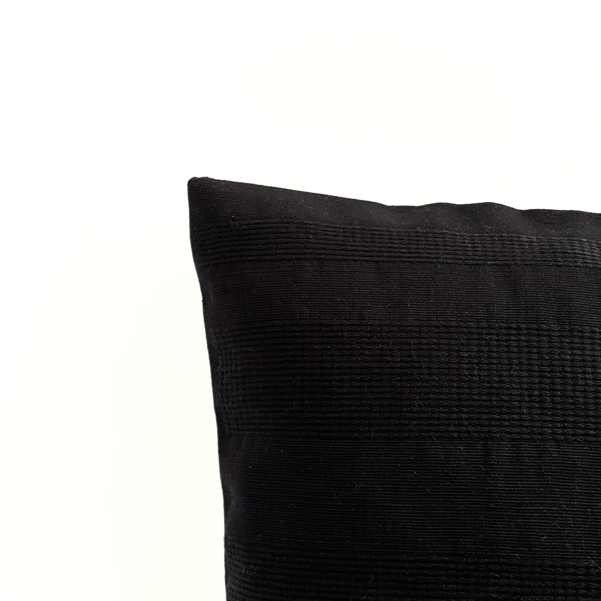 Black pillow cover crafted by the artisans of Magnolia Casual called the Lines Pillow Cover Black featuring handwoven textile, handcrafted shown against a clean backdrop featuring shades of black.