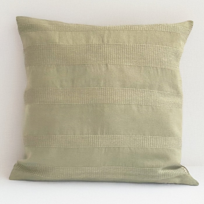 Green pillow cover crafted by the artisans of Magnolia Casual called the Lines Pillow Cover Green featuring handwoven textile, handcrafted shown against a clean backdrop featuring shades of green.