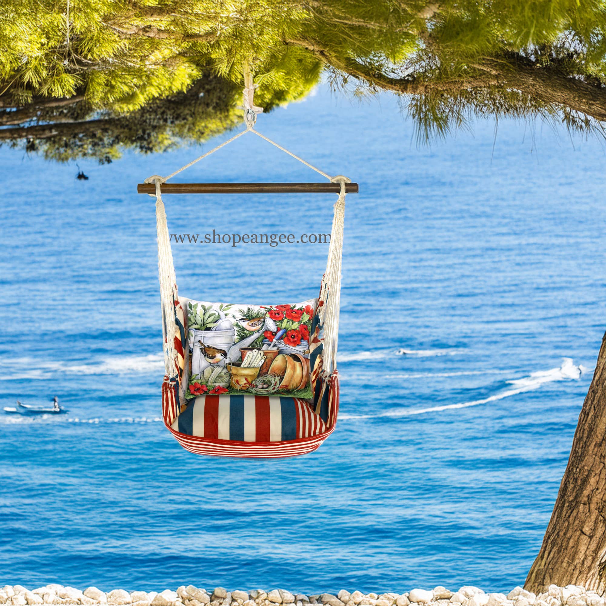 In an outdoor reading nook a multi colored outdoor swing crafted by the artisans of Magnolia Casual called the Swing Set 4 piece Stars & Stripes w/ Watering Can & Flower Pots is displayed featuring 100 percent weather resistant fabric, weather resistant polyester fabric, handcrafted adding comfort and style to the space featuring with a stripes motif.