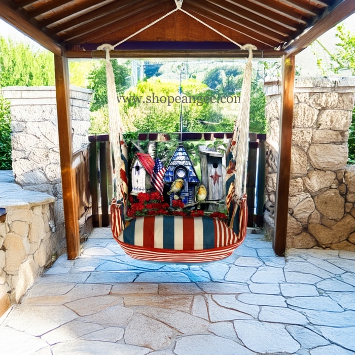 In a poolside chaise a multi colored outdoor swing crafted by the artisans of Magnolia Casual called the Swing Set 4 piece Stars & Stripes w/ Americana Birdhouses is displayed featuring 100 percent weather resistant fabric, weather resistant polyester fabric, handcrafted adding comfort and style to the space featuring with a stripes motif.