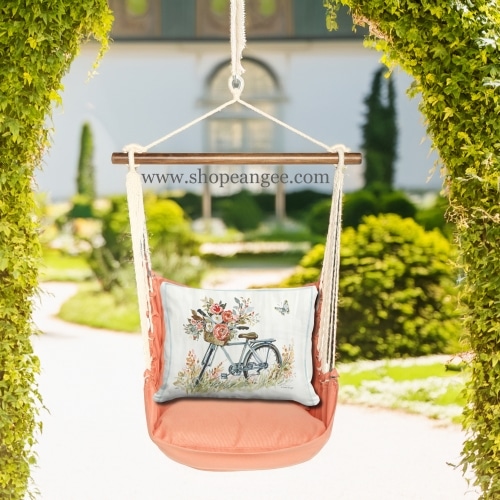 In a shaded porch swing a multi colored outdoor swing crafted by the artisans of Magnolia Casual called the Swing Set 4 piece Living Coral w/ Bike with Flower Basket is displayed featuring 100 percent weather resistant fabric, weather resistant polyester fabric, handcrafted adding comfort and style to the space featuring with a coral motif and shades of coral.