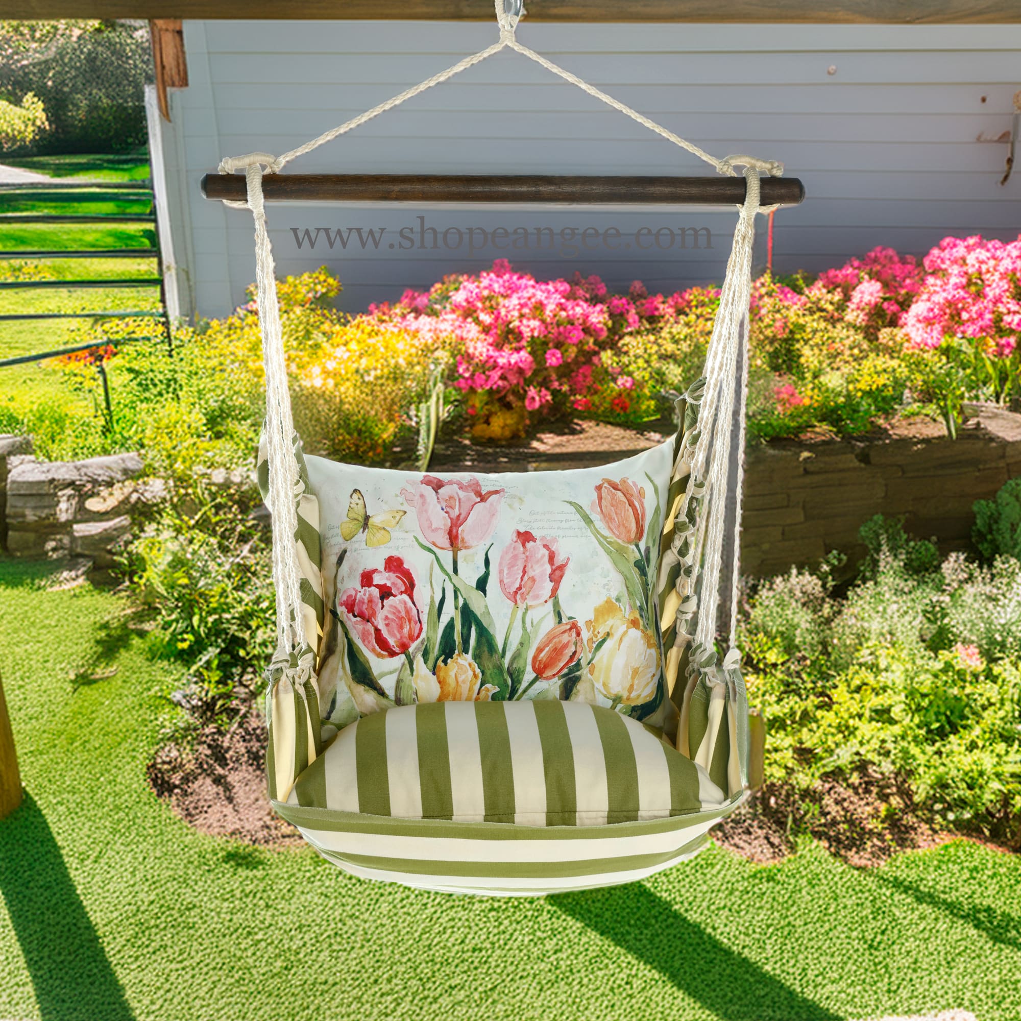 In a shaded porch swing a pink outdoor swing crafted by the artisans of Magnolia Casual called the Swing Set 4 piece Summer Palms Stripe w/ Pink and Yellow Tulips is displayed featuring 100 percent weather resistant fabric, weather resistant polyester fabric, handcrafted adding comfort and style to the space featuring with a stripe motif and shades of pink and yellow.