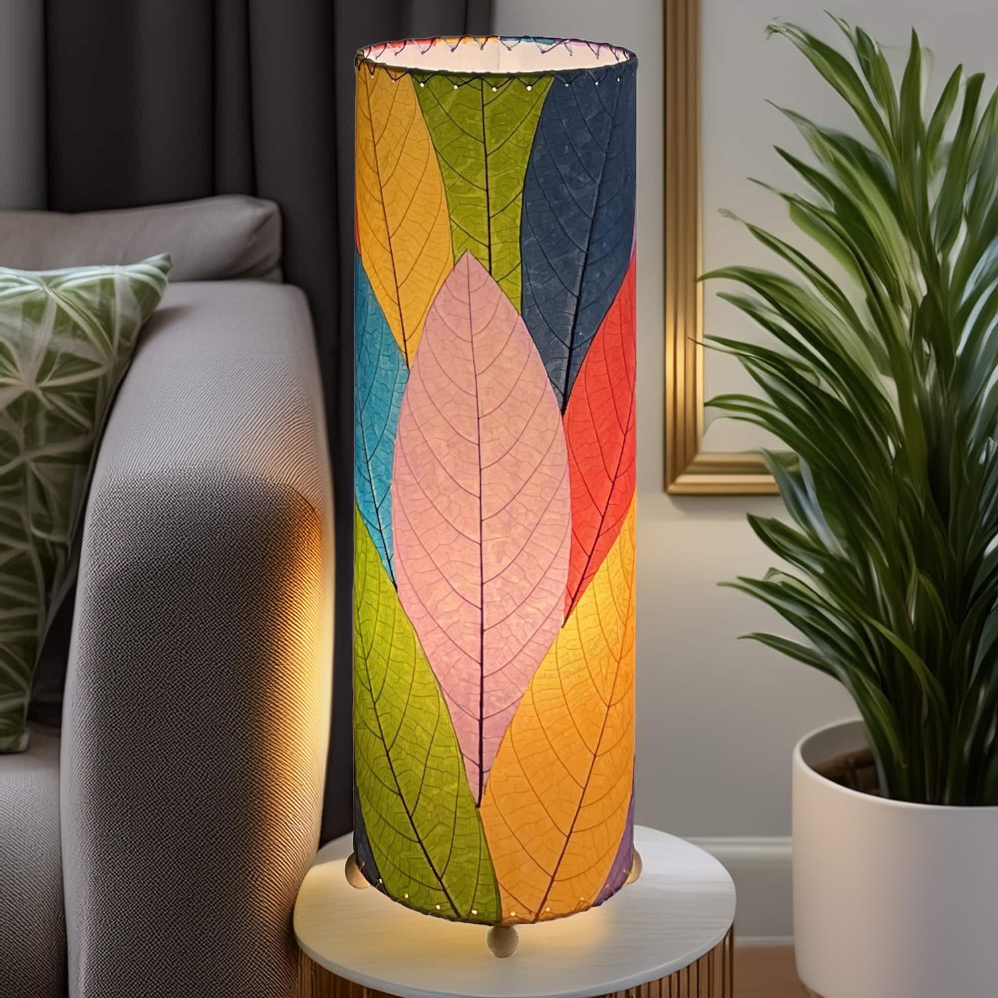 Slim cylinder table lamp crafted by Eangee Home Design in multi color fossilized cocoa leaves, each panel hand?laminated and stitched; minimalist form offers textural leaf detail while cozy light glows through the natural leaf veins; handcrafted sustainably by fair?trade artisans