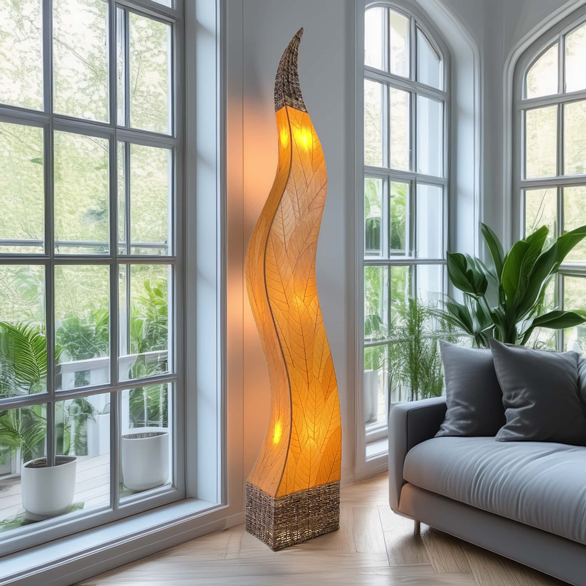 In a studio setting, the Flame Giant crafted by the artisans of Eangee Home Design Lamp in orange finish by Eangee Home Design creates an inviting atmosphere with its fossilized cocoa leaf panels, abaca twine accents, and hand placed natural leaves.