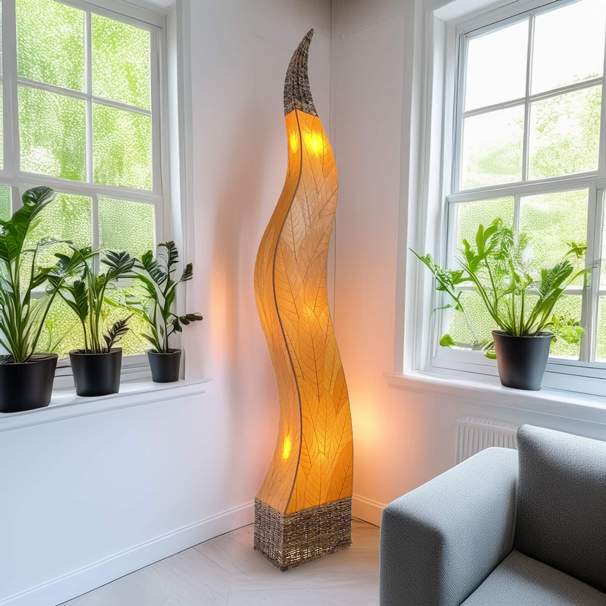 In a sun drenched entryway, crafted by the artisans of Eangee Home Design, the Flame Giant Lamp in orange stands gracefully, featuring fossilized cocoa leaf shade, abaca rope accents, fair trade, adding warmth and character to the space.