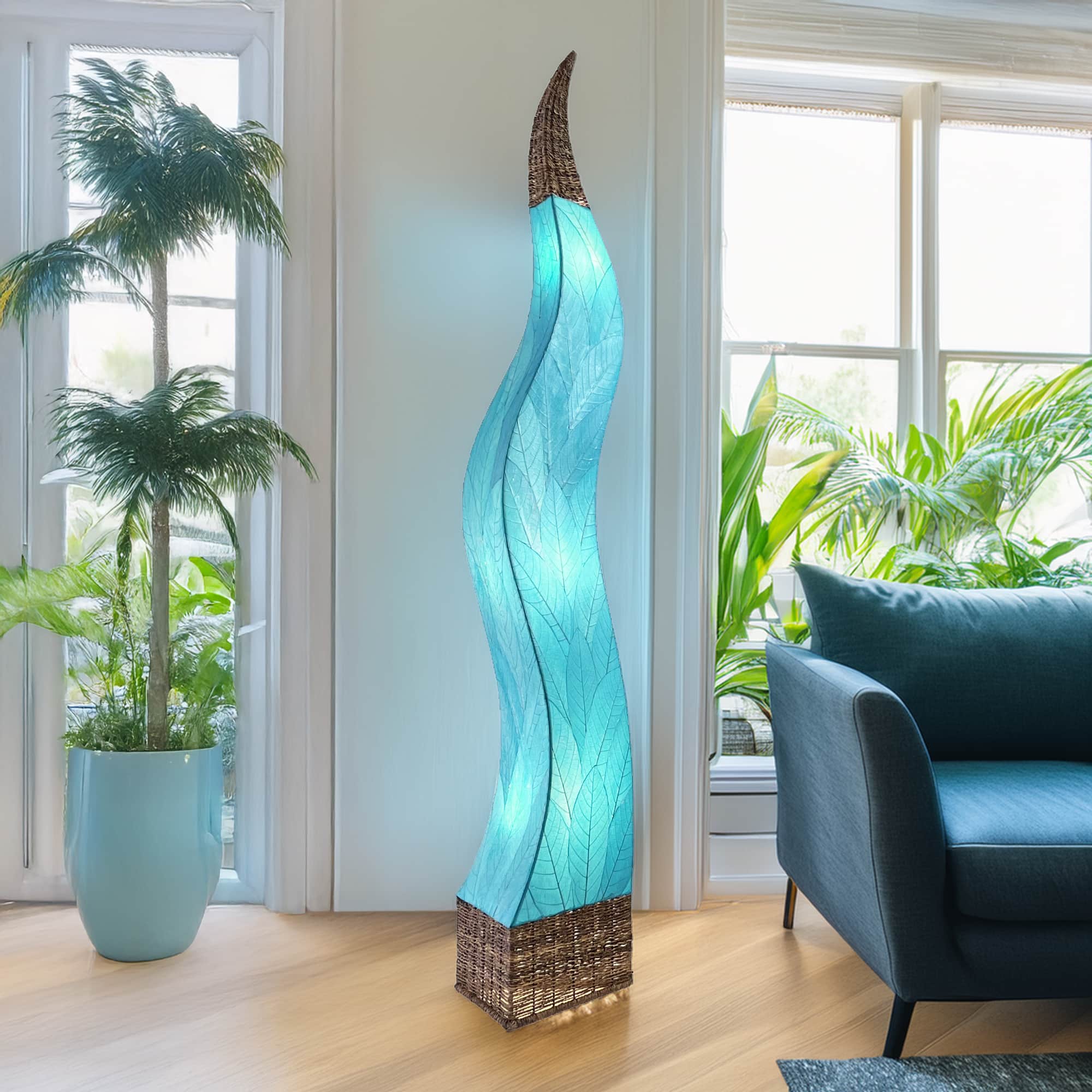 In a minimalist loft with natural textures, crafted by the artisans of Eangee Home Design, the Flame Giant Lamp in sea blue stands gracefully, featuring fossilized cocoa leaf shade, abaca rope accents, fair trade, adding warmth and character to the space.