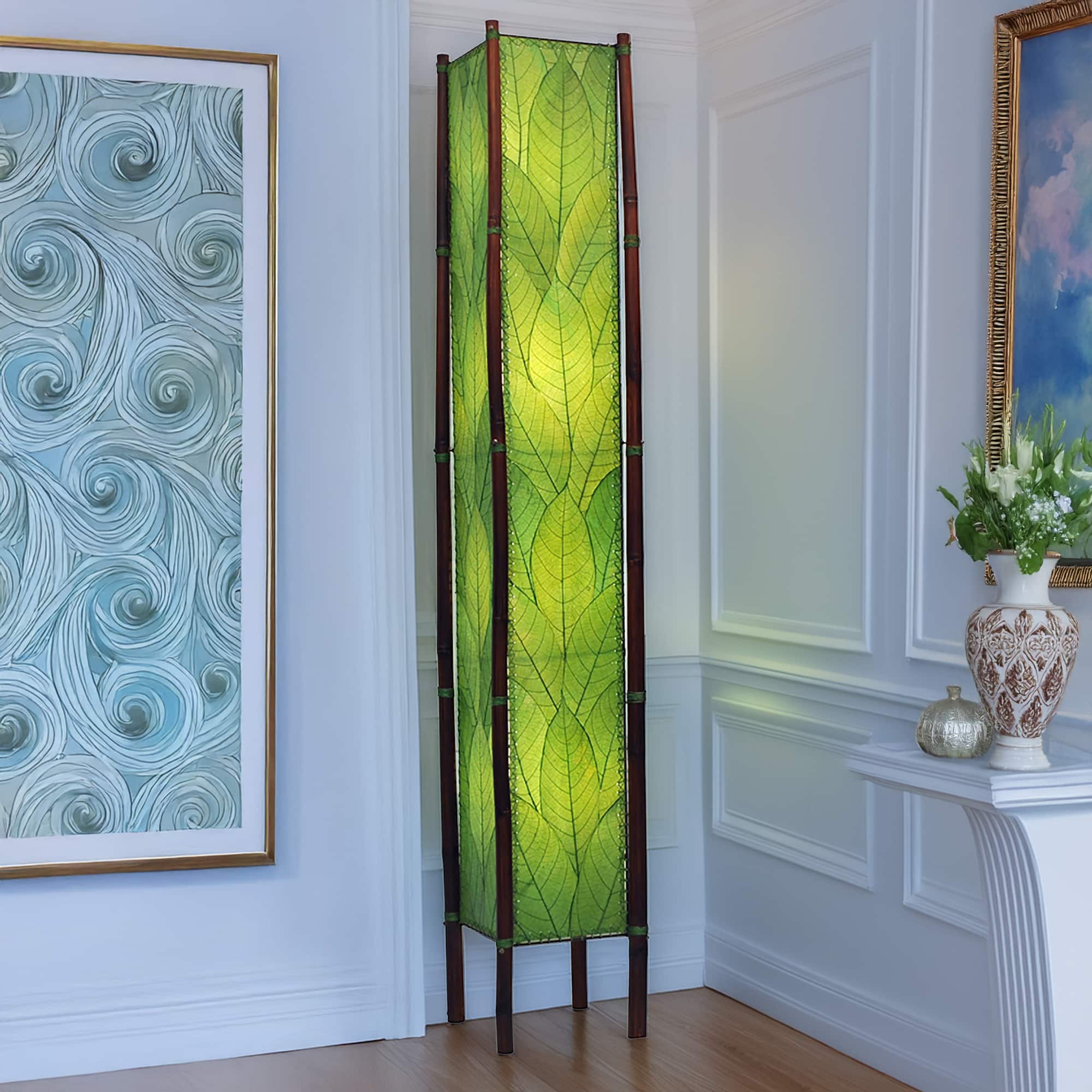 In a coastal living room, the Fortune Giant Floor crafted by the artisans of Eangee Home Design Lamp in green finish by Eangee Home Design stands tall, its fossilized cocoa leaf panels, abaca twine accents, rattan legs, powder coated wrought iron frame, wrought iron frame, hand placed natural leaves, hand placed leaf panels, and abaca twine stitching casting a warm glow that some pieces don't just fill a space they define it.