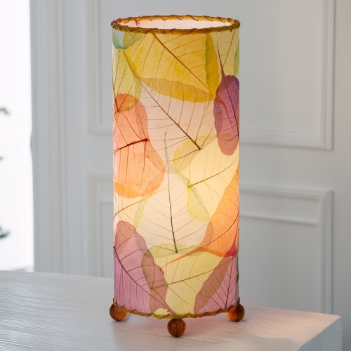In a coastal inspired living room, crafted by the artisans of Eangee Home Design, the Banyan Table Lamp in multi color stands gracefully, featuring wrought iron frame, eco friendly, adding warmth and character to the space.