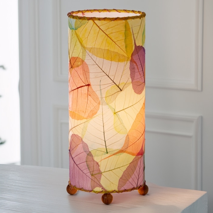 In a coastal inspired living room, crafted by the artisans of Eangee Home Design, the Banyan Table Lamp in multi color stands gracefully, featuring wrought iron frame, eco friendly, adding warmth and character to the space.