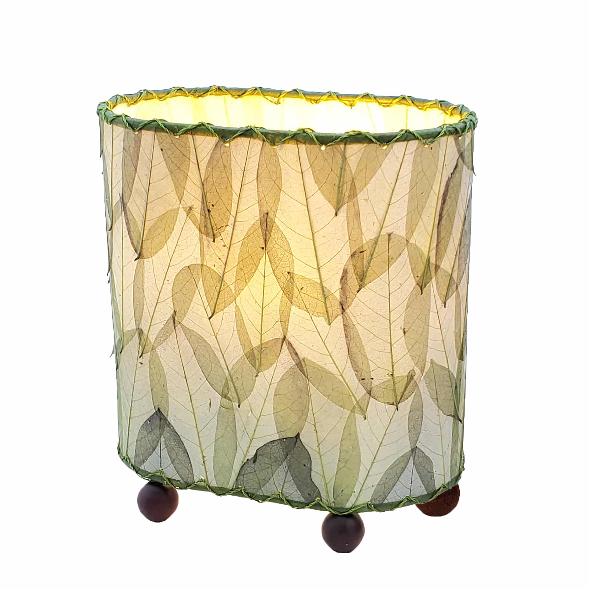 Crafted by the artisans of Eangee Home Design, the Mini Guyabano Table Lamp in green against a clean backdrop, featuring fossilized cocoa leaf shade, guyabano leaf shade, wrought iron frame.