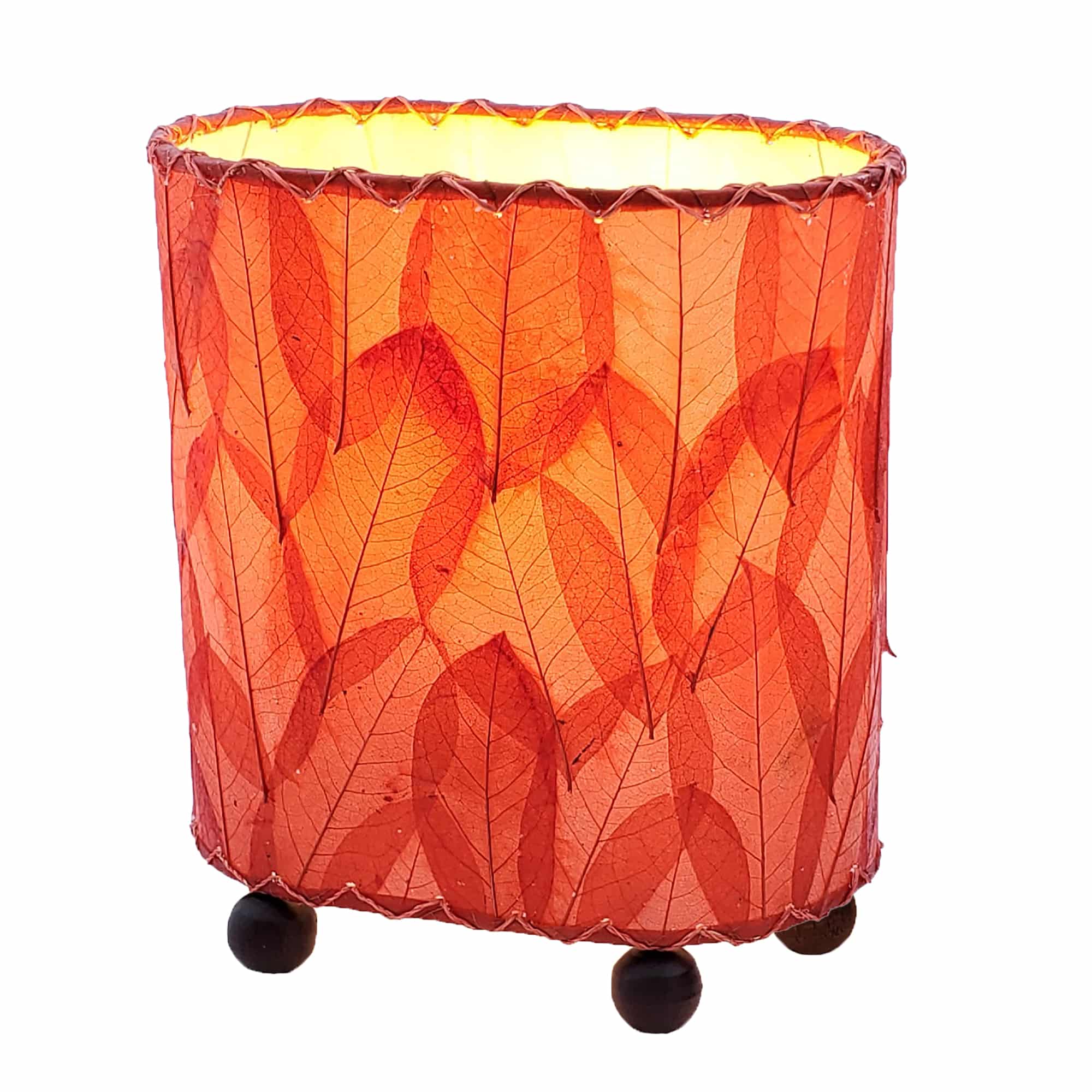 Crafted by the artisans of Eangee Home Design, the Mini Guyabano Table Lamp in red against a clean backdrop, featuring fossilized cocoa leaf shade, guyabano leaf shade, wrought iron frame.