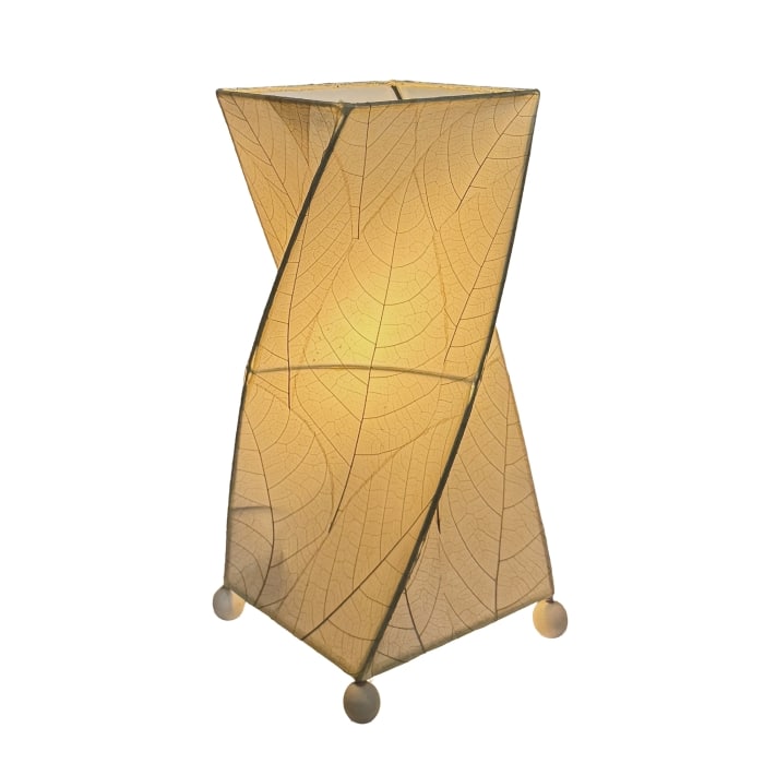 Crafted by the artisans of Eangee Home Design, the Twist Table Lamp in natural against a clean backdrop, featuring fossilized cocoa leaf shade, wrought iron frame, handcrafted.