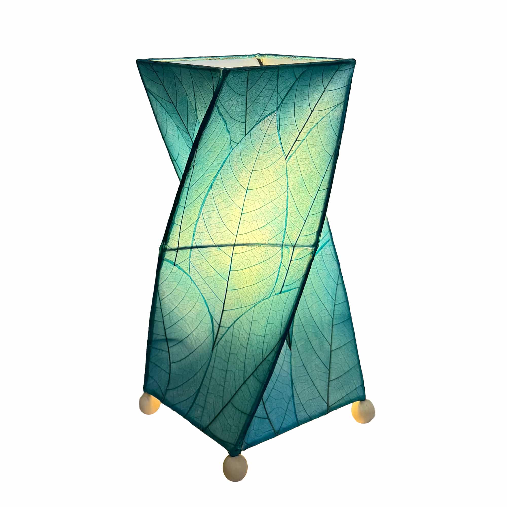 Crafted by the artisans of Eangee Home Design, the Twist Table Lamp in sea blue against a clean backdrop, featuring fossilized cocoa leaf shade, wrought iron frame, handcrafted.