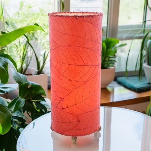 Slim cylinder table lamp crafted by Eangee Home Design in red fossilized cocoa leaves, each panel hand?laminated and stitched; minimalist form offers textural leaf detail while soothing light shines through the natural leaf veins; eco?friendly, artisan?crafted design