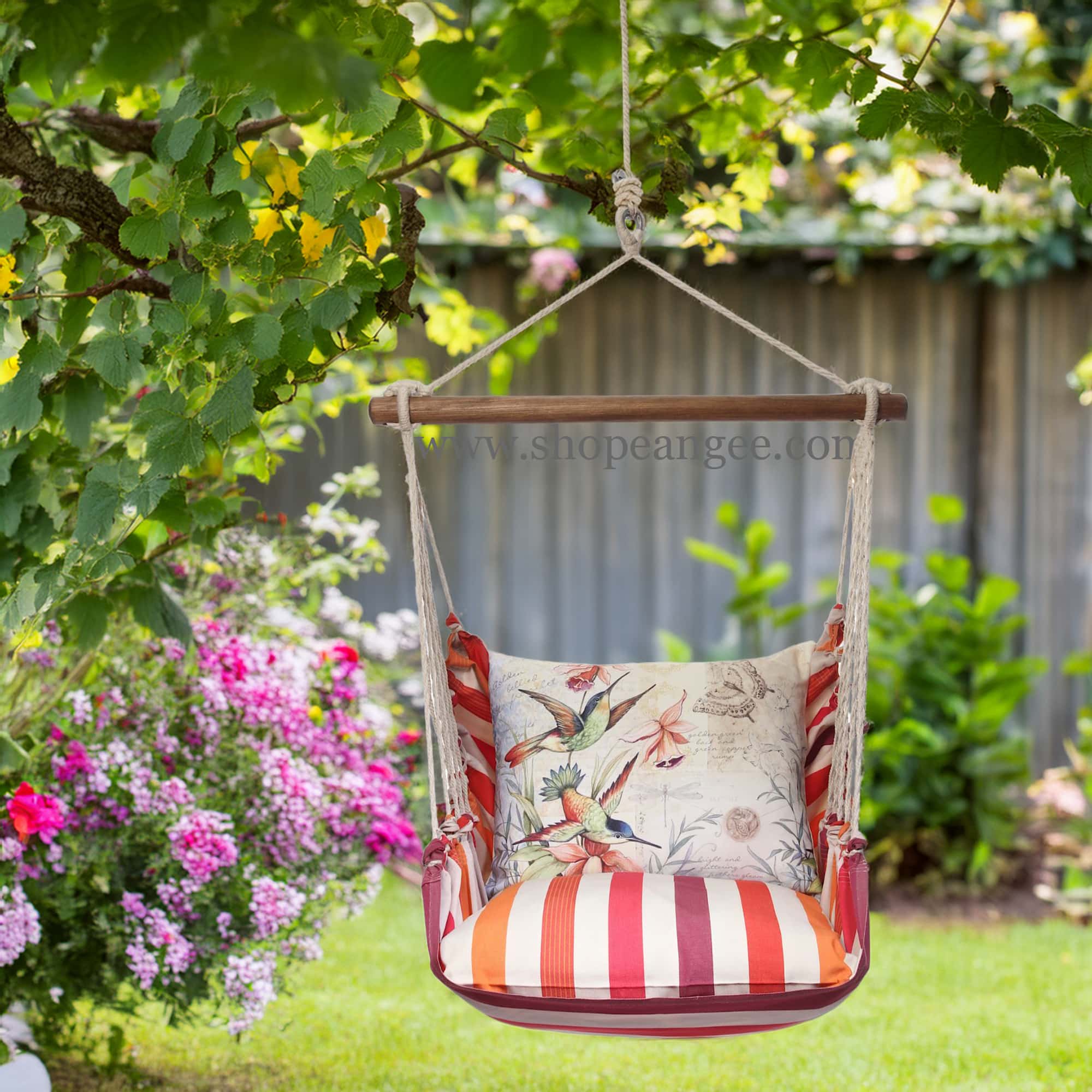 In a poolside chaise a multi colored outdoor swing crafted by the artisans of Magnolia Casual called the Swing Set 4 piece Cristina Stripe w/ Hummingbirds is displayed featuring 100 percent weather resistant fabric, weather resistant polyester fabric, handcrafted adding comfort and style to the space featuring with a stripe motif.