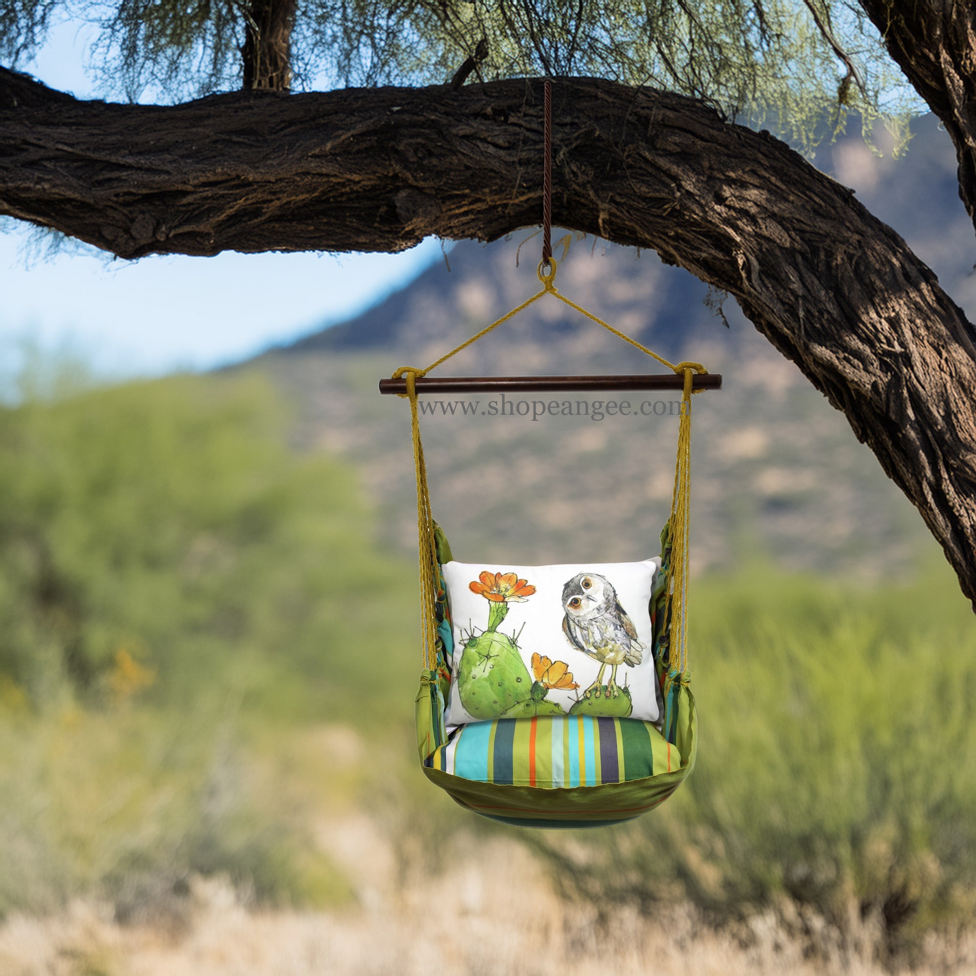 In a shaded porch swing a multi colored outdoor swing crafted by the artisans of Magnolia Casual called the Swing Set 4 piece Citrus Stripe w/ Owl on Prickly Cactus is displayed featuring 100 percent weather resistant fabric, weather resistant polyester fabric, handcrafted adding comfort and style to the space featuring with a stripe motif.