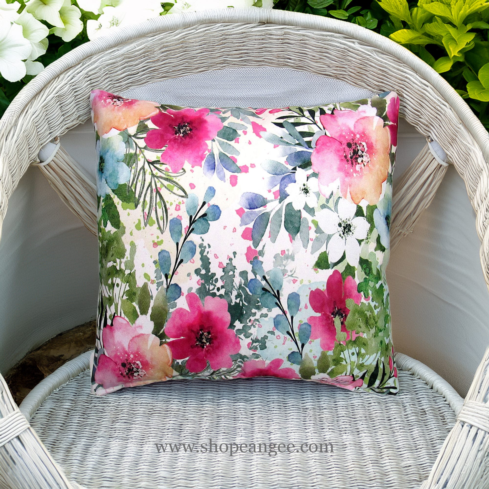 In a shaded porch swing a multi colored outdoor pillow crafted by the artisans of Magnolia Casual called the Outdoor Pillow Meadow Dance 1 18x18 is displayed featuring 100 percent weather resistant fabric adding comfort and style to the space.