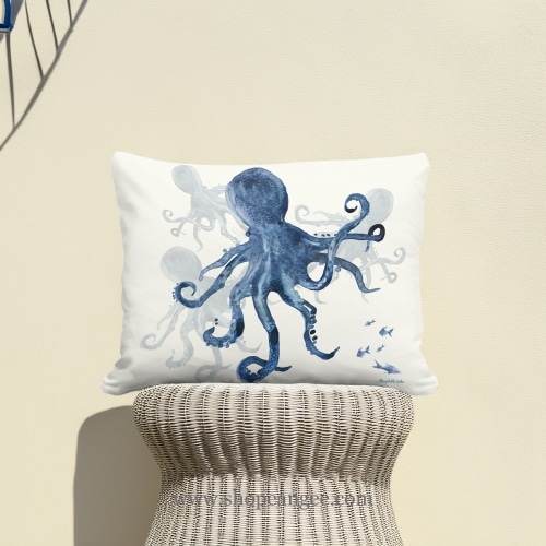 In a coastal inspired deck chair a multi colored outdoor pillow crafted by the artisans of Magnolia Casual called the Outdoor Pillow Indigo Octopus 19x24 is displayed featuring quality outdoor fabric adding comfort and style to the space featuring with a octopus motif.