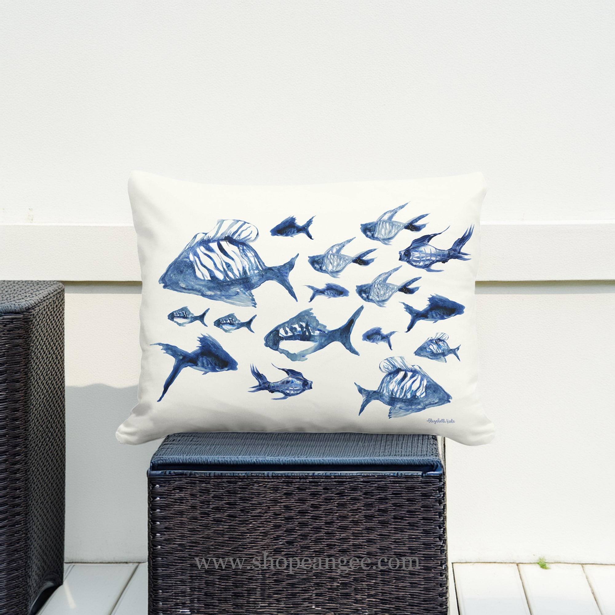 In an outdoor reading nook a multi colored outdoor pillow crafted by the artisans of Magnolia Casual called the Outdoor Pillow Underwater Ballet 19x24 is displayed featuring quality outdoor fabric adding comfort and style to the space.