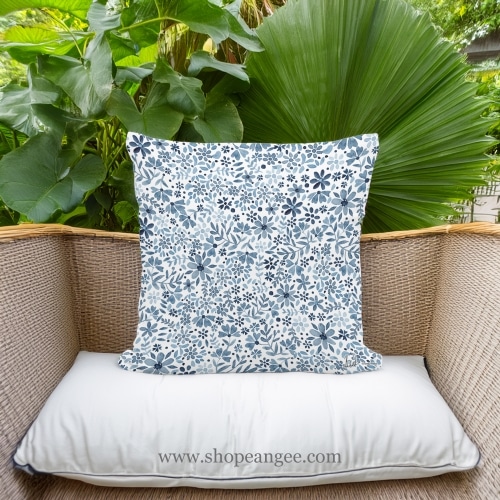 In a coastal inspired deck chair a multi colored outdoor pillow crafted by the artisans of Magnolia Casual called the Outdoor Pillow Indigo Flourish 18x18 is displayed featuring quality outdoor fabric adding comfort and style to the space.