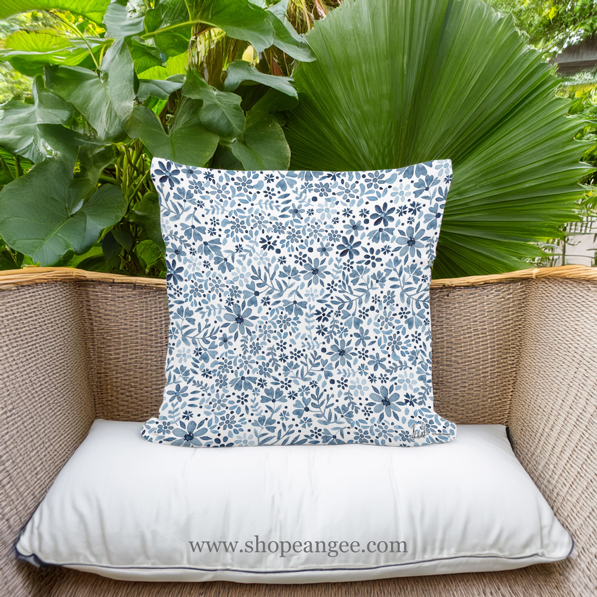 In a coastal inspired deck chair a multi colored outdoor pillow crafted by the artisans of Magnolia Casual called the Outdoor Pillow Indigo Flourish 18x18 is displayed featuring quality outdoor fabric adding comfort and style to the space.