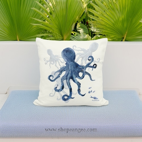 In a coastal inspired deck chair a multi colored outdoor pillow crafted by the artisans of Magnolia Casual called the Outdoor Pillow Indigo Octopus 18x18 is displayed featuring quality outdoor fabric adding comfort and style to the space featuring with a octopus motif.