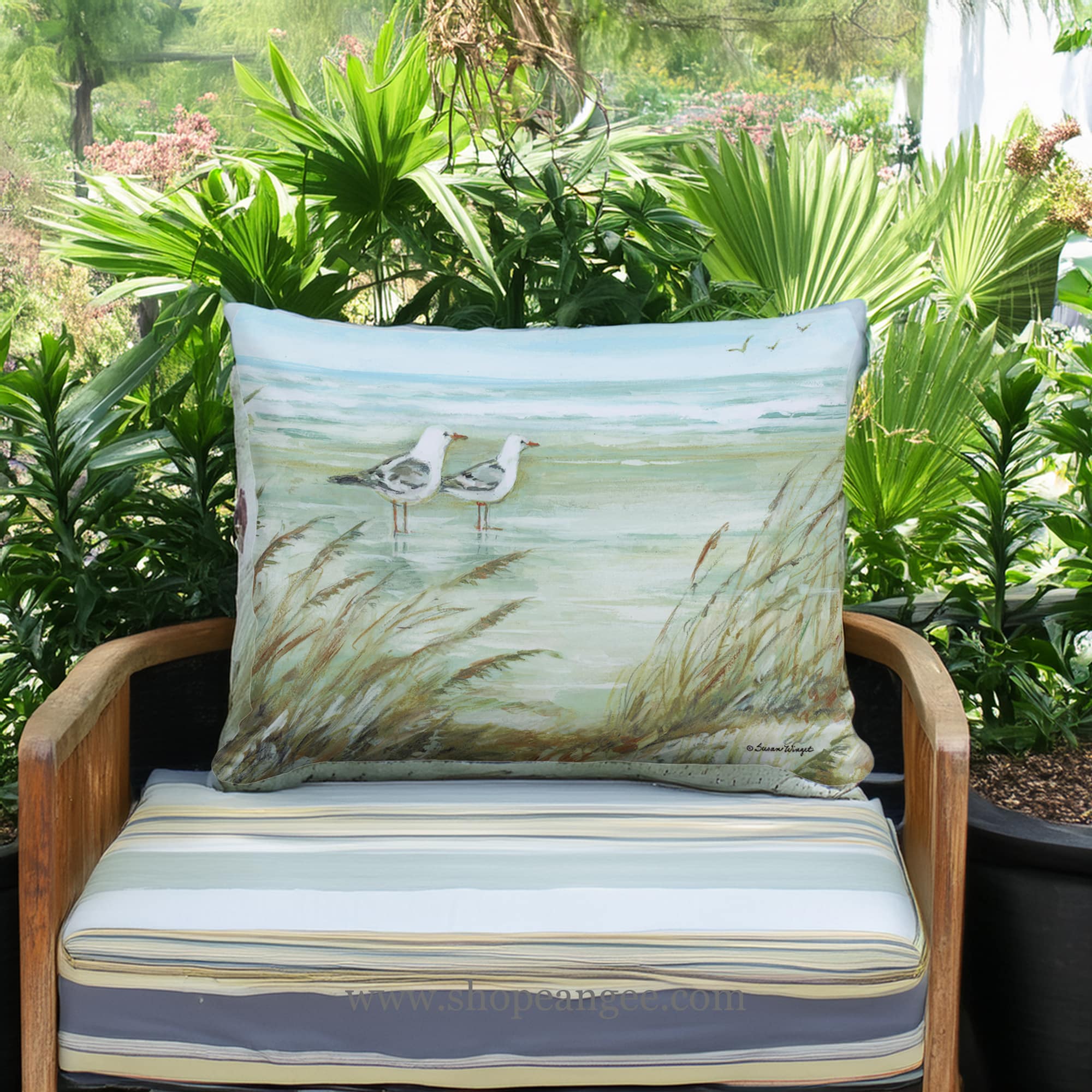 In a coastal inspired deck chair a multi colored outdoor pillow crafted by the artisans of Magnolia Casual called the Outdoor Pillow Seagulls on Beach 13x18 is displayed featuring quality outdoor fabric adding comfort and style to the space.
