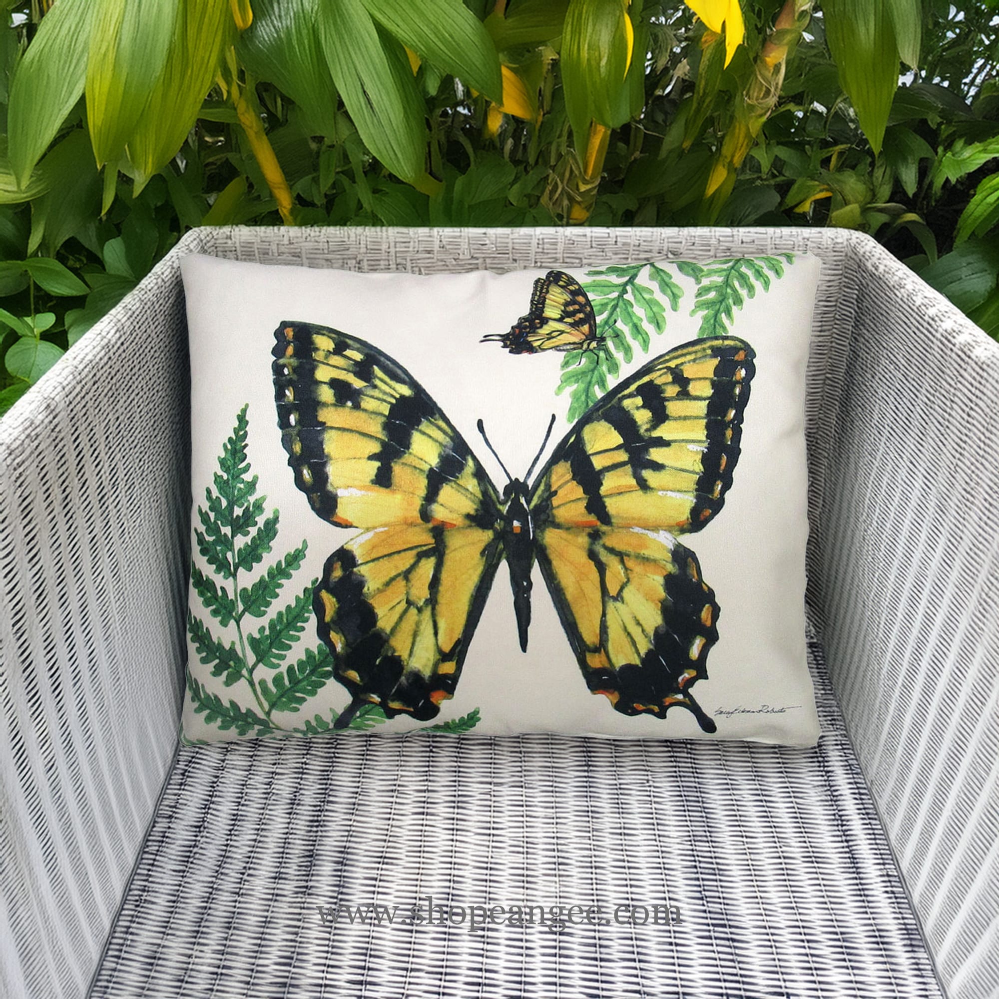 In a coastal inspired deck chair a multi colored outdoor pillow crafted by the artisans of Magnolia Casual called the Outdoor Pillow Beautiful Butterfly 19x24 is displayed featuring quality outdoor fabric adding comfort and style to the space featuring with a butterfly motif.