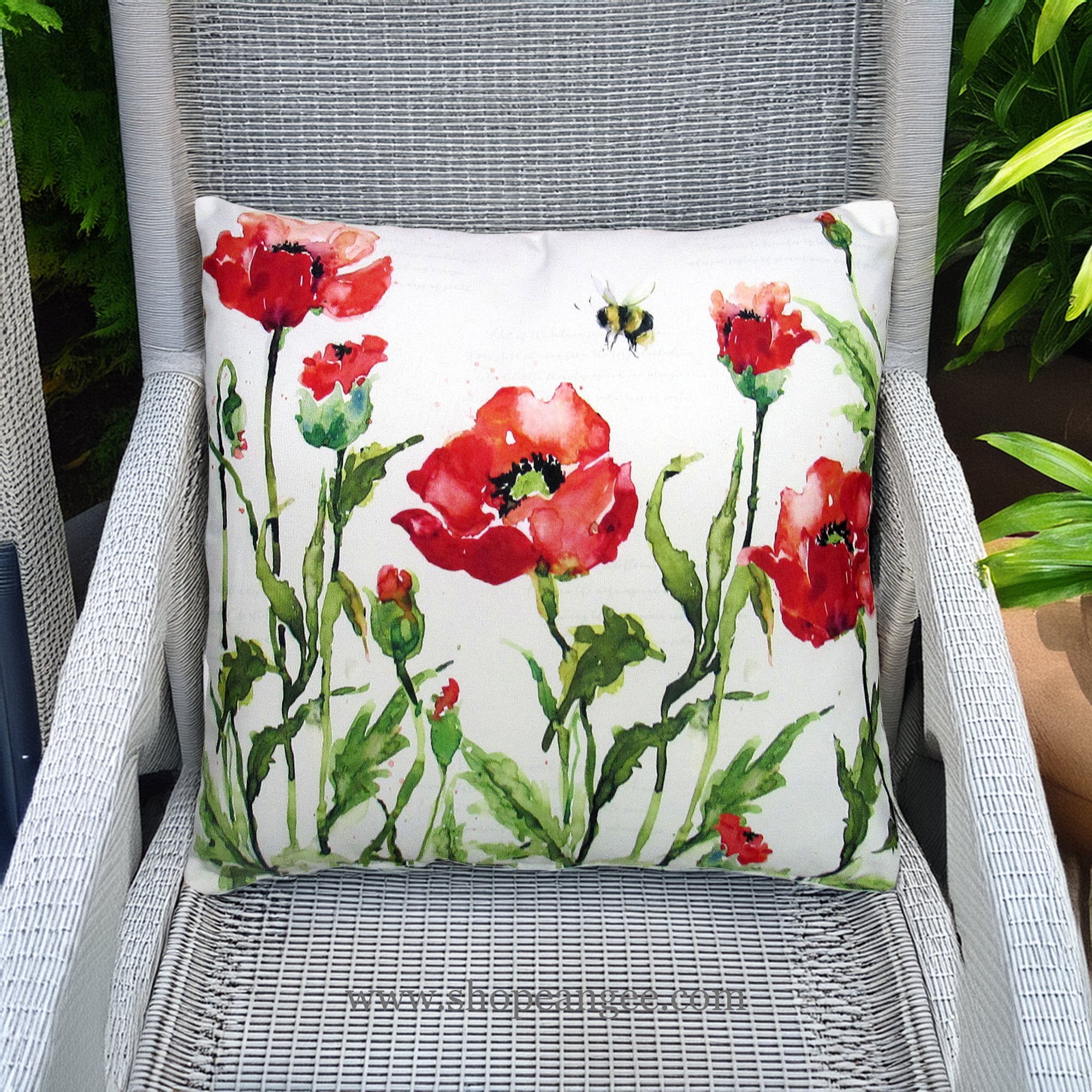 In a poolside chaise a multi colored outdoor pillow crafted by the artisans of Magnolia Casual called the Outdoor Pillow Poppies and Bee 18x18 is displayed featuring handwoven textile adding comfort and style to the space featuring with a bee motif.