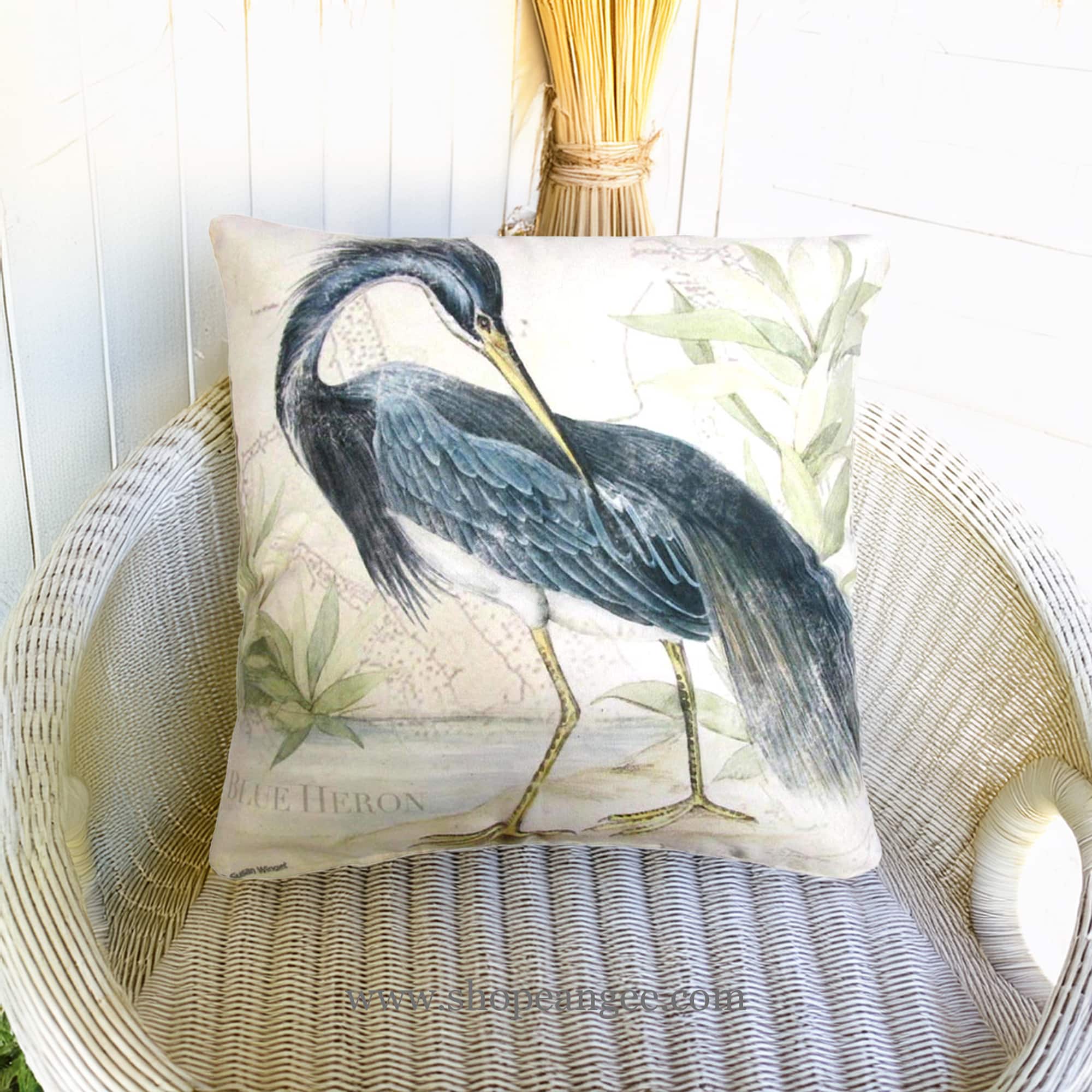 In a shaded porch swing a multi colored outdoor pillow crafted by the artisans of Magnolia Casual called the Outdoor Pillow Great Heron 2 18x18 is displayed featuring quality outdoor fabric, natural materials adding comfort and style to the space.
