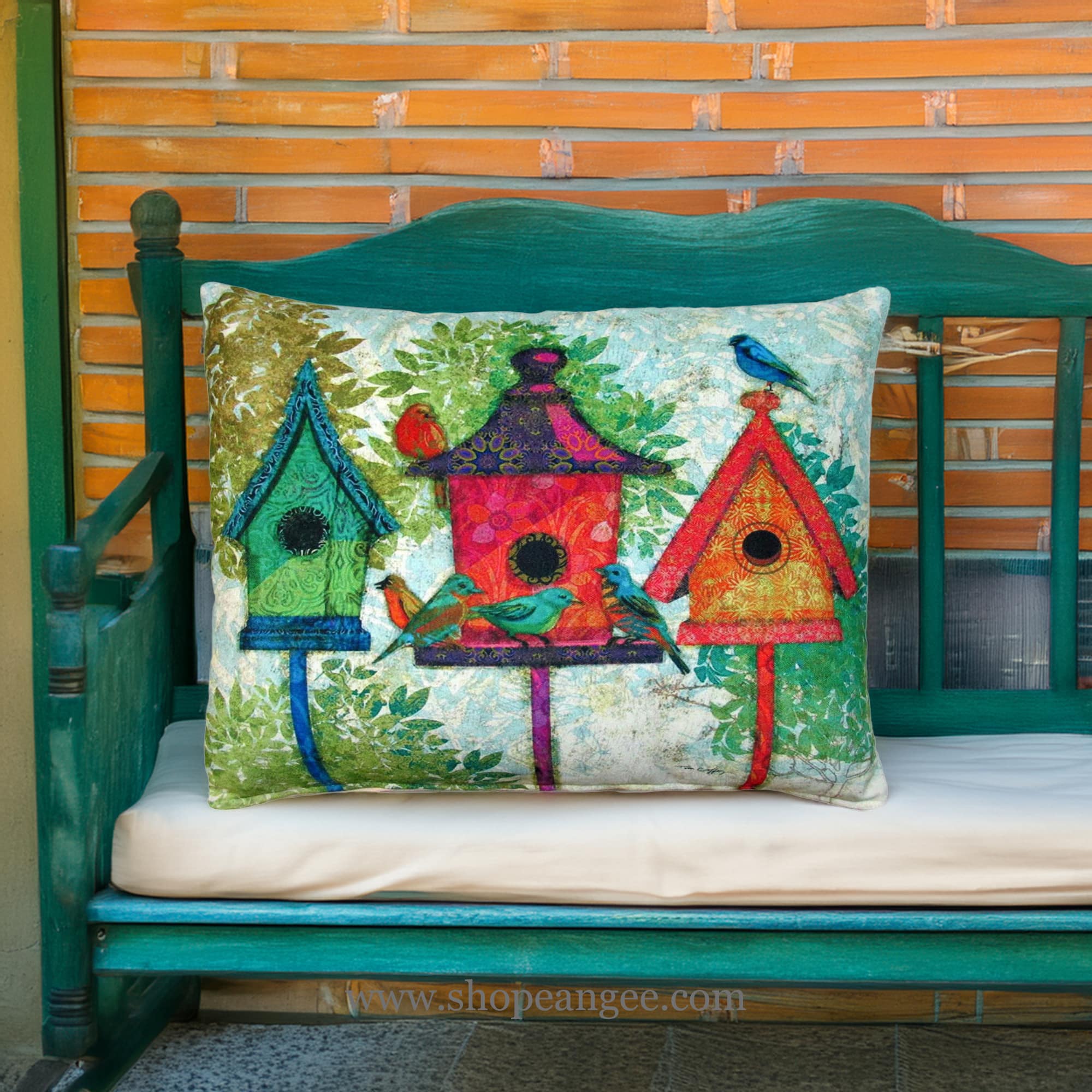 In a poolside chaise a multi colored outdoor pillow crafted by the artisans of Magnolia Casual called the Outdoor Pillow 3 Birdhouses 19x24 is displayed featuring quality outdoor fabric adding comfort and style to the space.