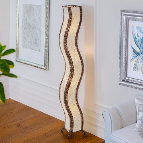 Natural Wave Giant Floor Lamp by Eangee Home Design - graceful wave form covered in neutral cocoa leaf panels and abaca trim; diffuses warm organic light, adding subtle movement beside contemporary artwork.